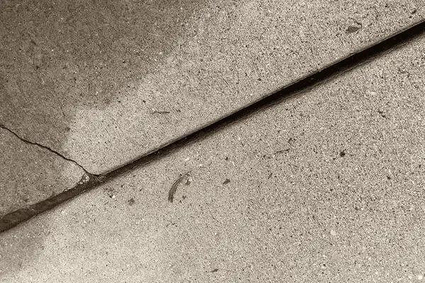Ground Up Foundation Repair, Waterproofing and Concrete Leveling inspecting cracking expansion joints in concrete.