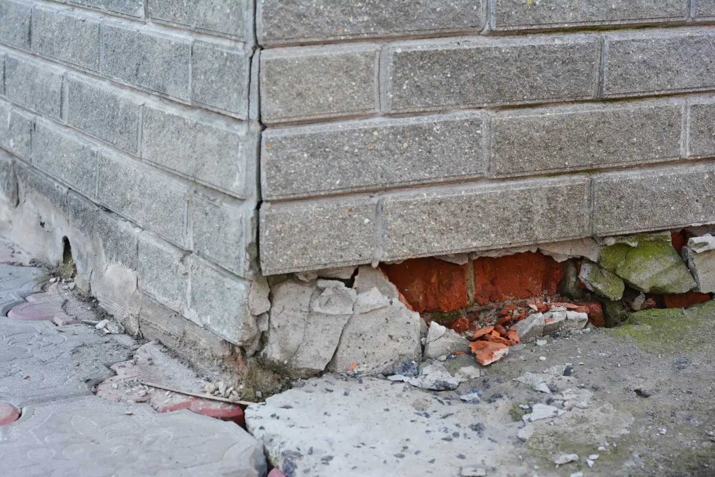 Ground Up Foundation Repair, Waterproofing and Concrete Leveling inspecting severe stair-step cracks in a block foundation.