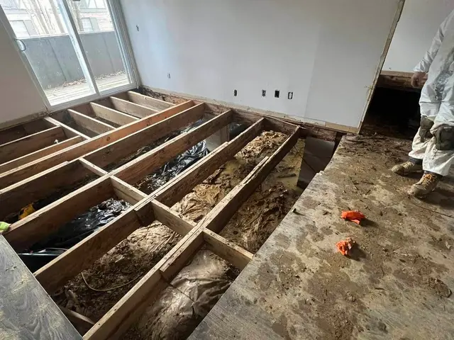 Severe basement flooding with exposed floor joists and structural damage from water.