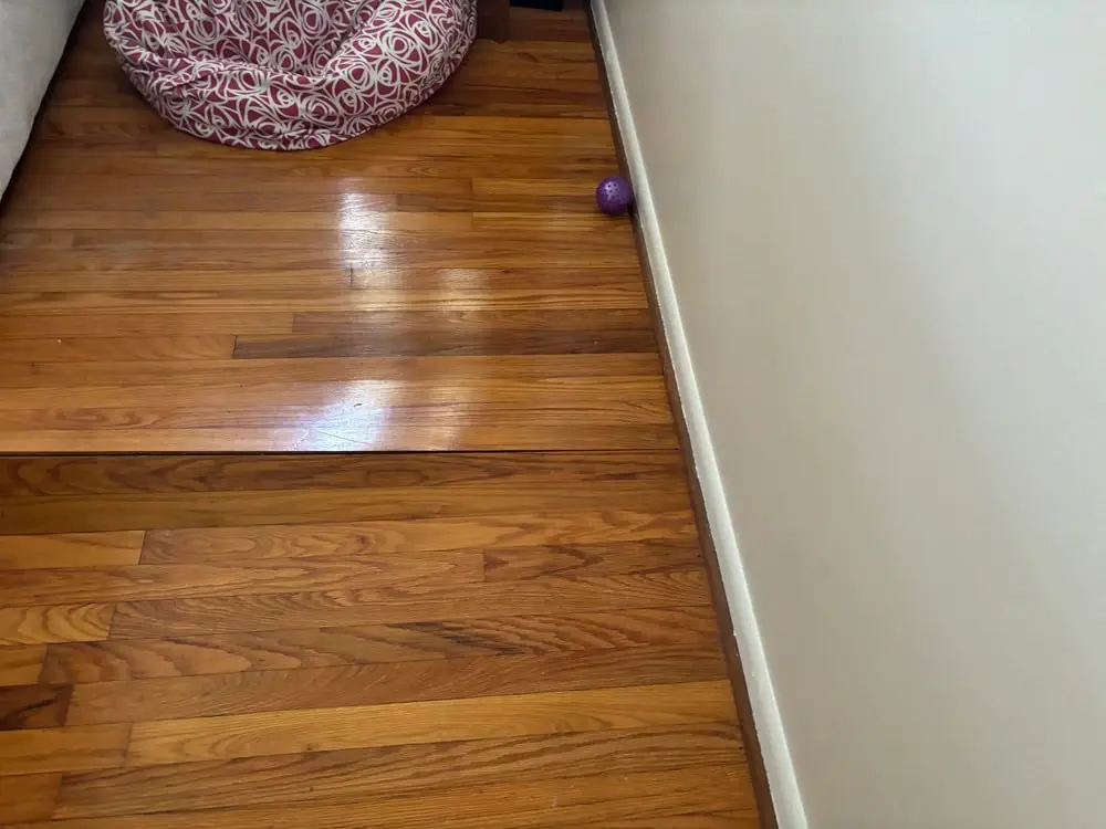 Ground Up Foundation Repair, Waterproofing and Concrete Leveling inspecting buckling hardwood floors caused by high humidity.