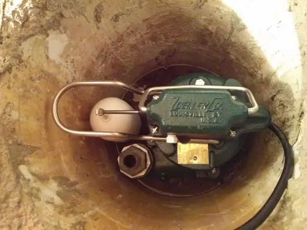Installing a sump pump for basement waterproofing.