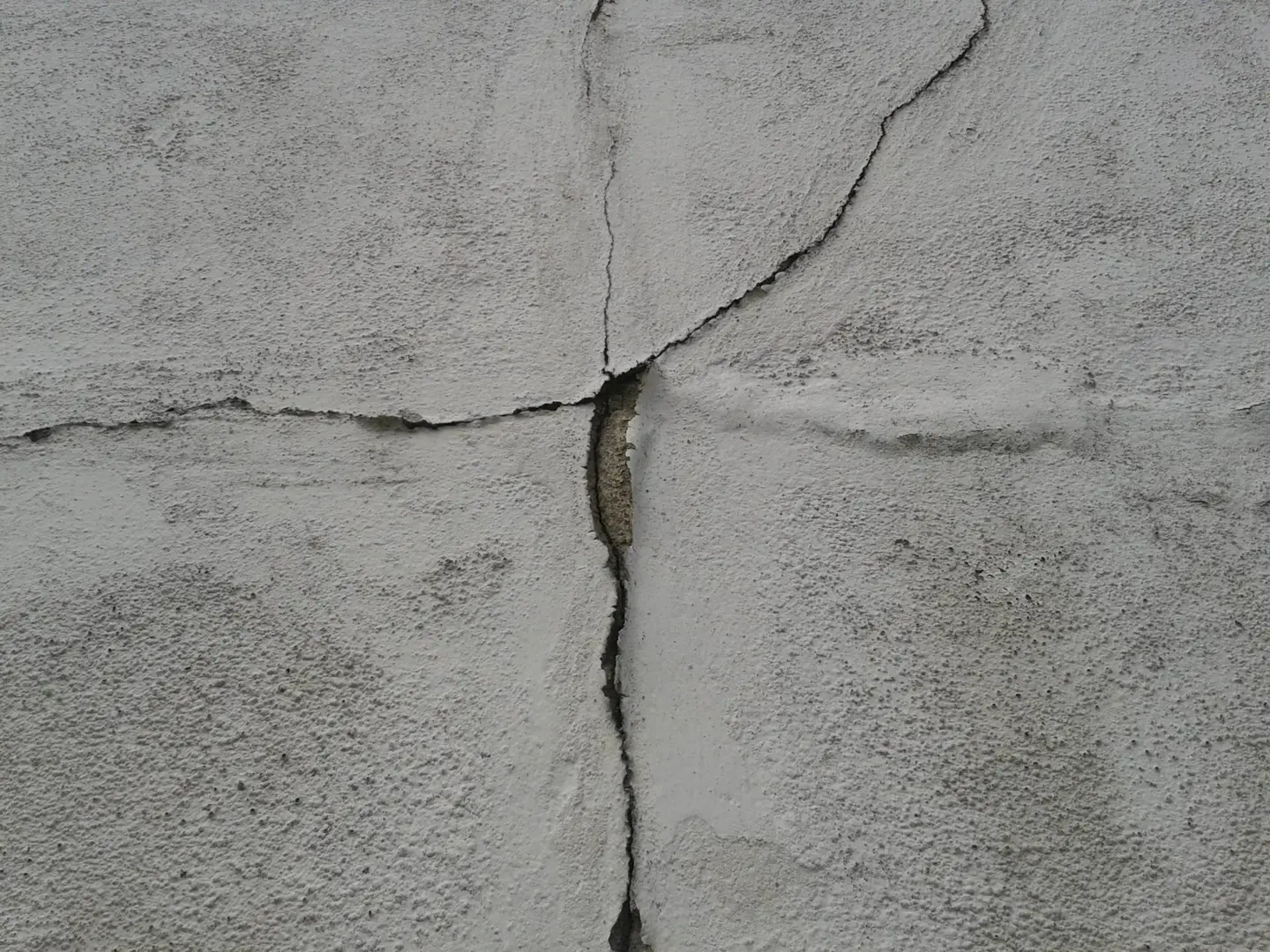 Ground Up Foundation Repair, Waterproofing and Concrete Leveling inspecting large cracks in a concrete foundation wall.