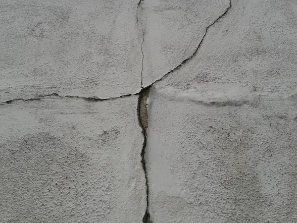 A prominent crack in a foundation wall indicating structural movement.