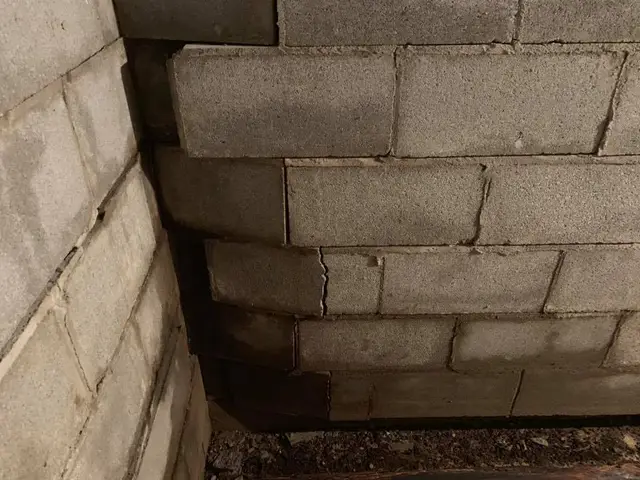 Ground Up Foundation Repair, Waterproofing and Concrete Leveling inspecting a bowing block foundation wall in a basement.