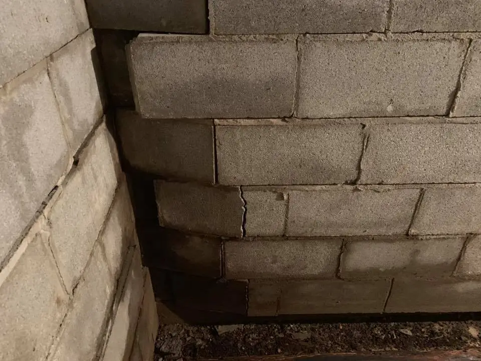 Ground Up Foundation Repair, Waterproofing and Concrete Leveling inspecting a bowing block foundation wall in a basement.
