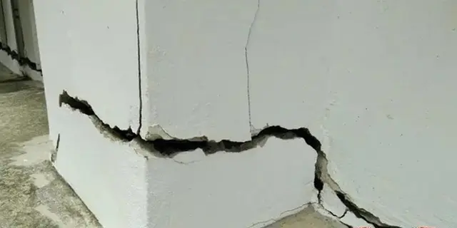 Ground Up Foundation Repair, Waterproofing and Concrete Leveling inspecting large, shifting cracks in a foundation wall.