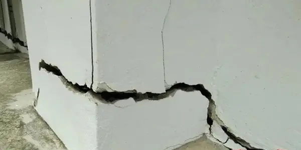 Ground Up Foundation Repair, Waterproofing and Concrete Leveling inspecting large, shifting cracks in a foundation wall.
