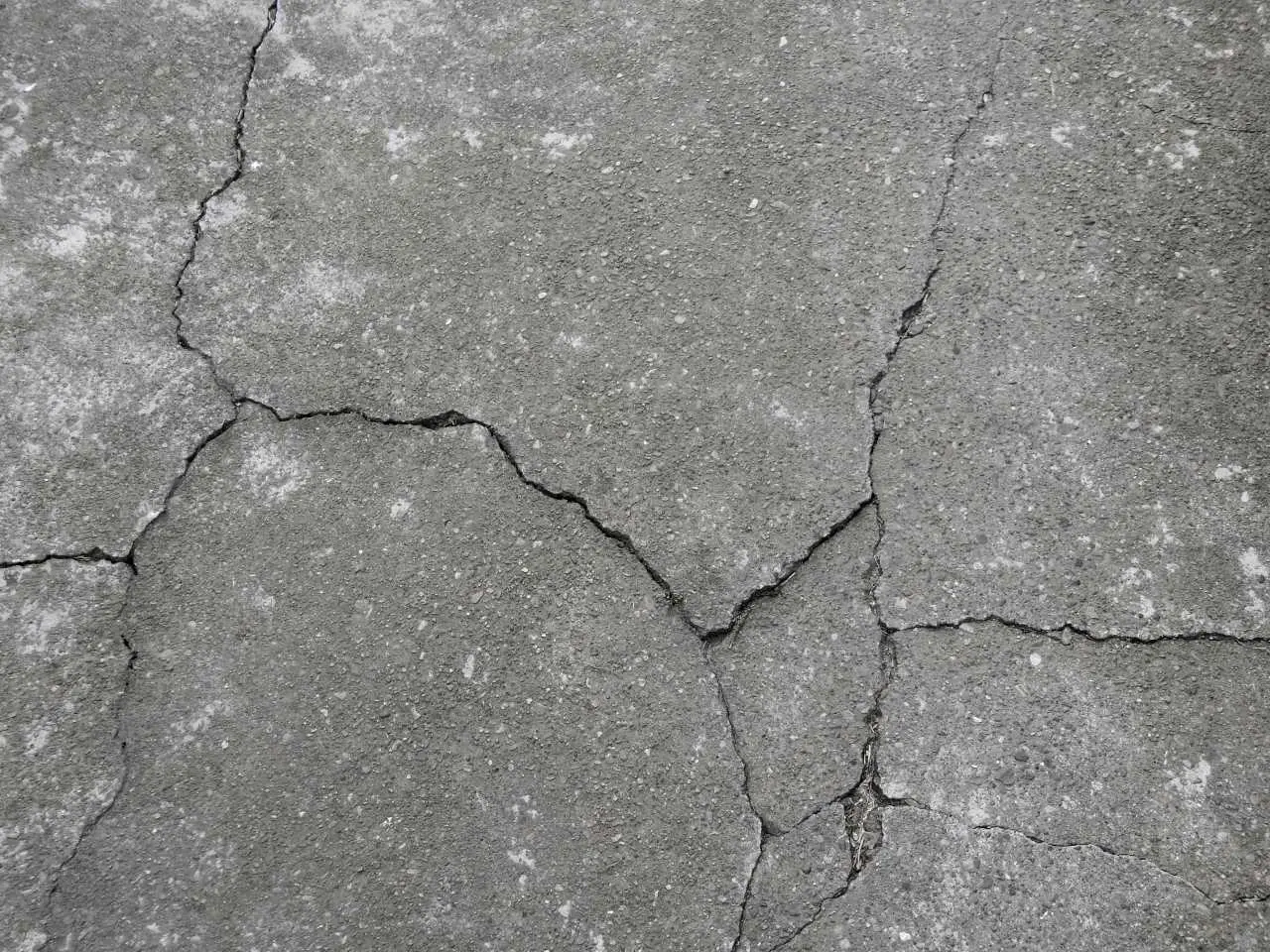 Ground Up Foundation Repair, Waterproofing and Concrete Leveling inspecting spiderweb cracks in concrete.