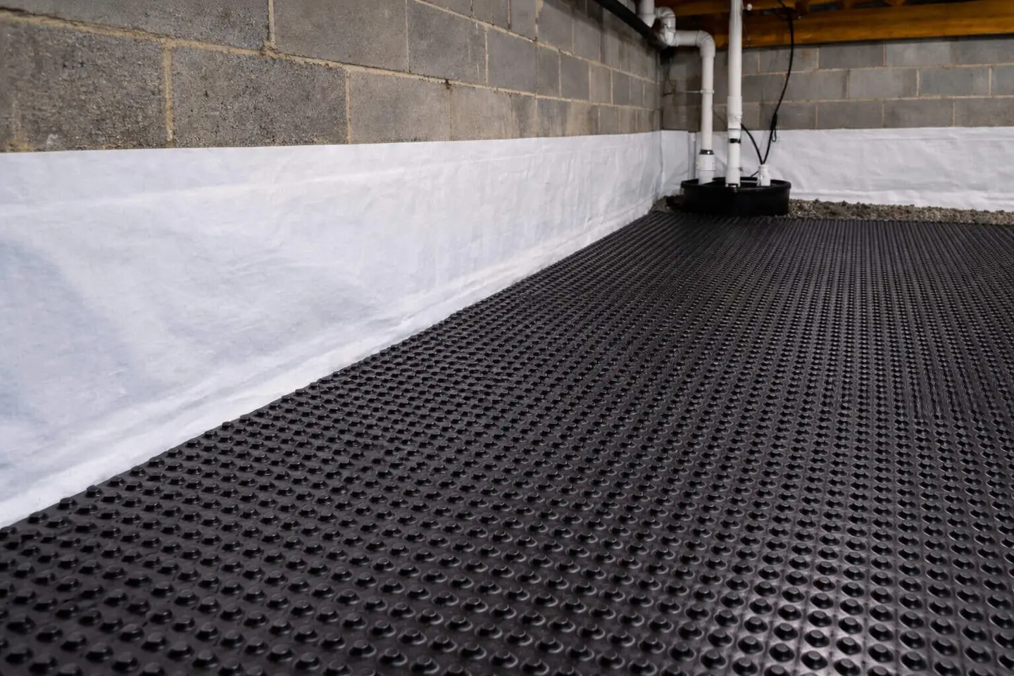 Ground Up Foundation Repair, Waterproofing and Concrete Leveling installing an interior drainage system in a basement.