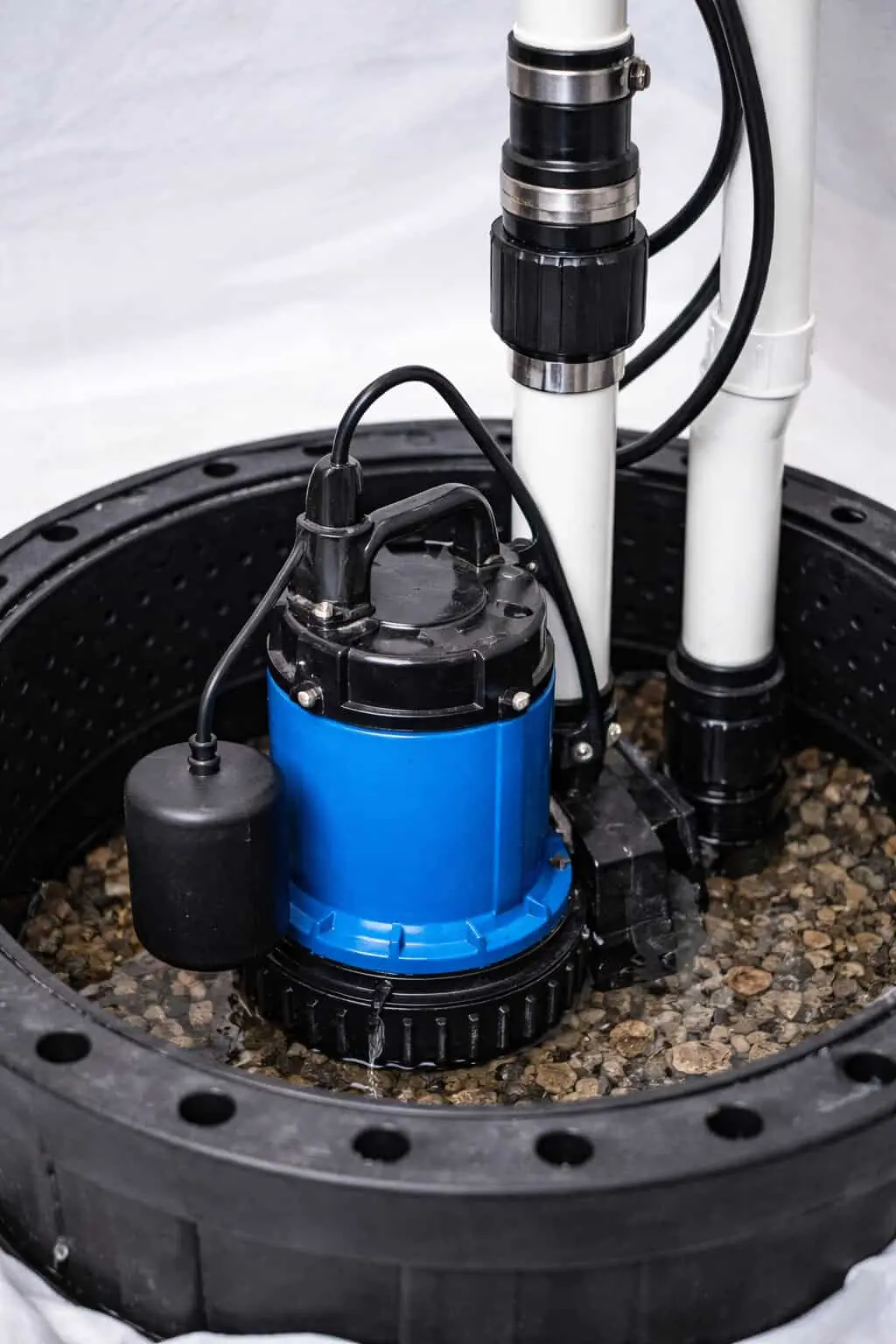 Ground Up Foundation Repair, Waterproofing and Concrete Leveling installing a new sump pump in a basement pit.