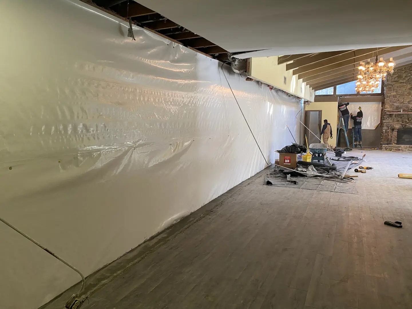 Ground Up Foundation Repair, Waterproofing and Concrete Leveling crew installing a basement wall liner.